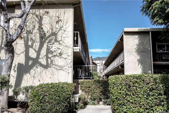 Front view of a multi-story building with an entryway and visible unit numbering.