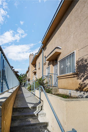 Side view of a multi-story building with balconies and staircases.