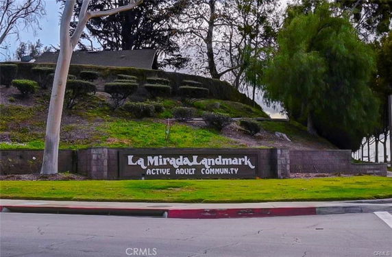 Front view of a sign indicating La Mirada Landmark Active Adult Community.