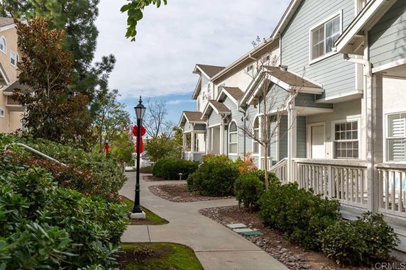 Front view of adjacent townhouse-style homes with porches.