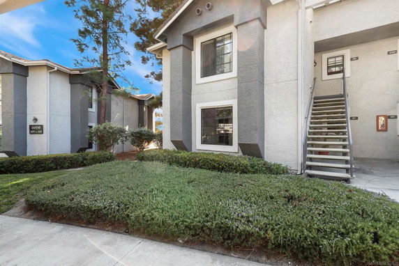 Front view of a multi-story residential building with exterior staircases.