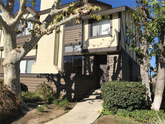 Front view of a two-story house with a mix of brown and cream exterior.