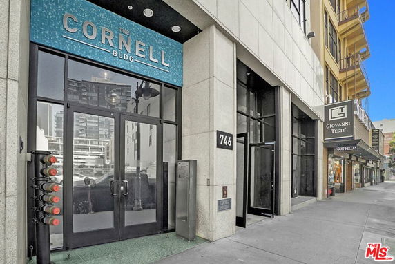 Front view of a commercial building entrance with glass doors and signage.