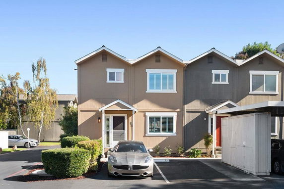 Front view of a two-story townhouse with a parked car in front.