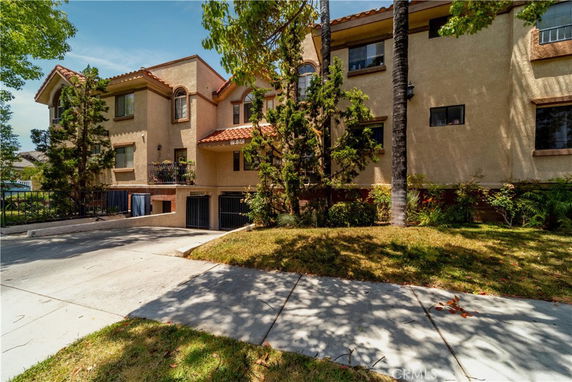 Front view of a multi-story residential building with a driveway.