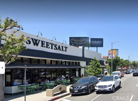 Front view of a commercial building with outdoor seating.