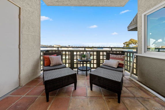Outdoor balcony seating area with panoramic view.