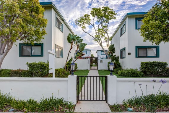 Front view of a residential building with a gated entrance and pathway.