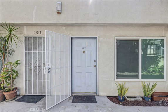 Front view of a building entrance with a white door and window.