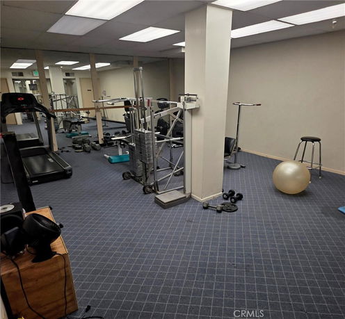 Indoor gym area with exercise equipment and mirrors.