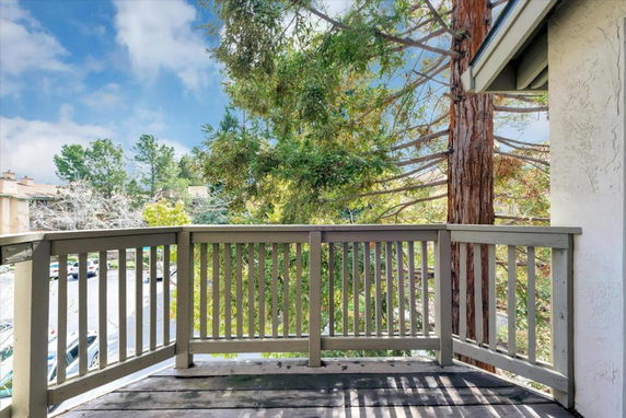 View from a balcony overlooking trees and surrounding buildings.