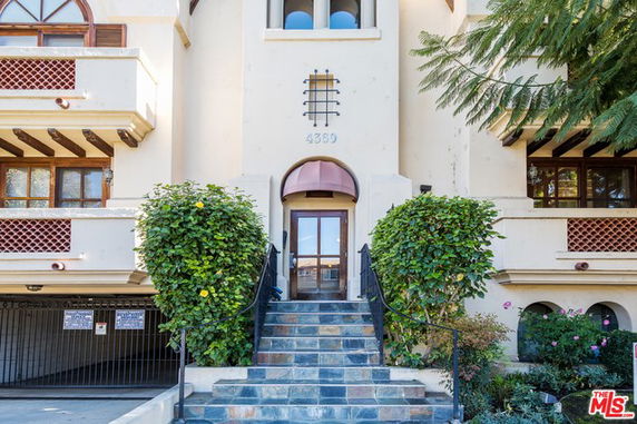 Front view of a multi-story building with a central entrance and decorative balconies.