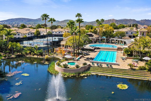 Outdoor view of a complex with multiple swimming pools and tennis courts.