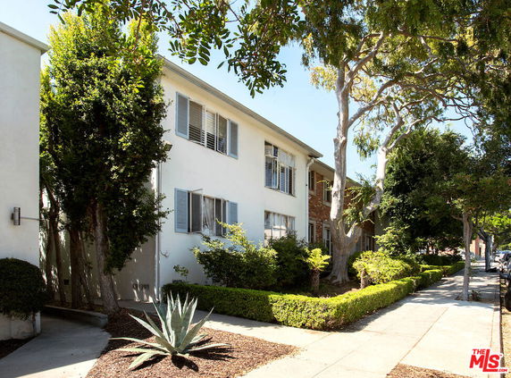 Front view of a two-story building with multiple windows and trees.