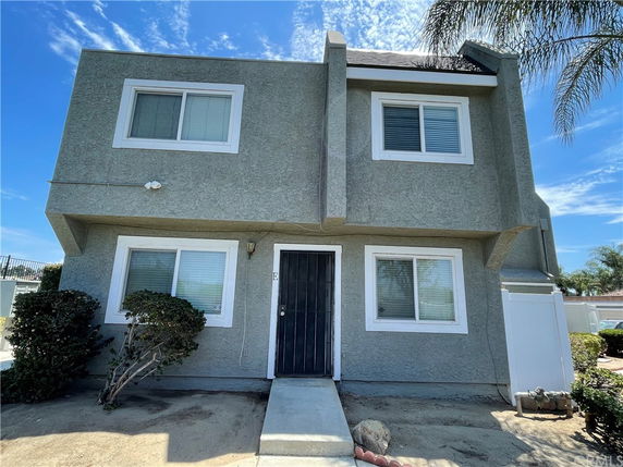 Front view of a two-story house with a central entrance and four windows.