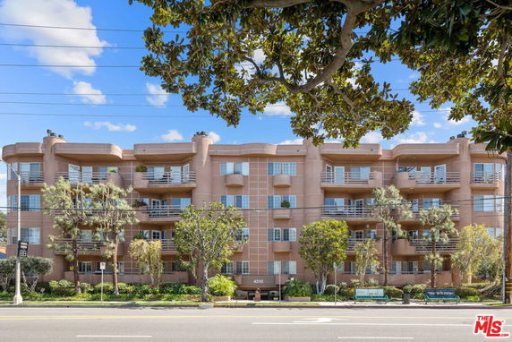 Front view of a multi-story residential building with balconies.