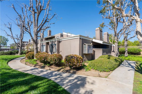 Side view of a single-story modern house with large windows and flat roof.