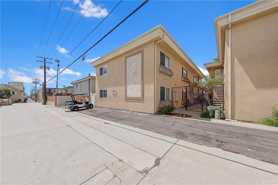 Side view of a two-story apartment building with a gated entrance.