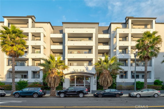 Front view of a multi-story apartment building with balconies and a prominent entrance.