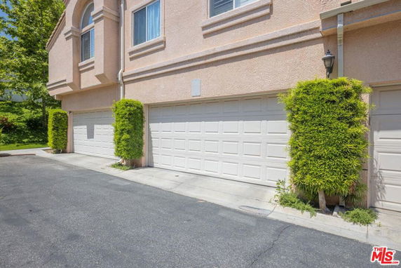 Front view of a two-story house with beige exterior and double garages.