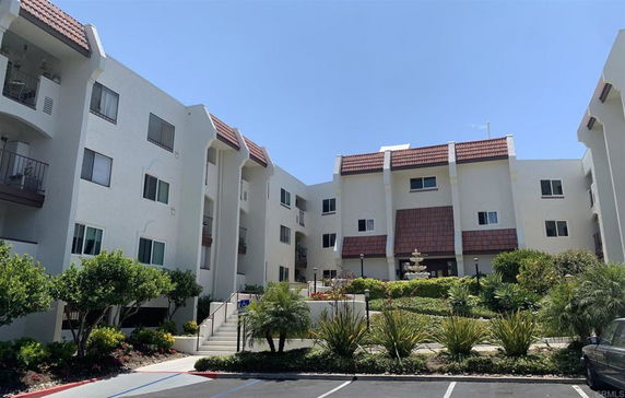 Front view of a multi-story building with a courtyard and fountain.