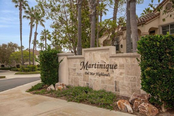 Front view of a residential building with stone signage reading 'Martinique Del Mar Highlands'.