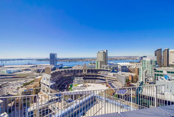 Panoramic view of a city skyline with a stadium and waterfront.