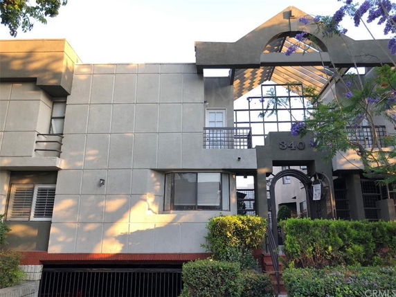 Front view of a multi-story building with modern architectural design and a gated entrance.
