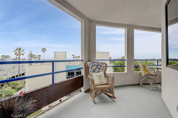 Balcony view with ocean and palm trees in the background