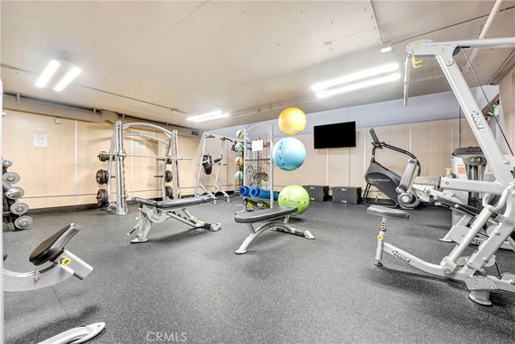 Indoor gym area with various exercise equipment and weights.