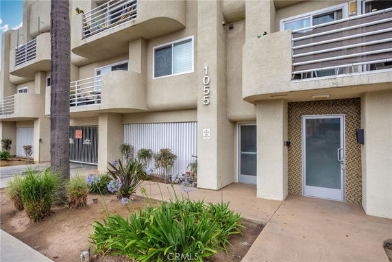 Front view of a multi-story building with balconies and a ground-level entrance.