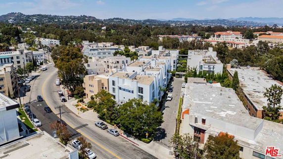 Aerial view of a residential area with multiple buildings and surrounding landscape.