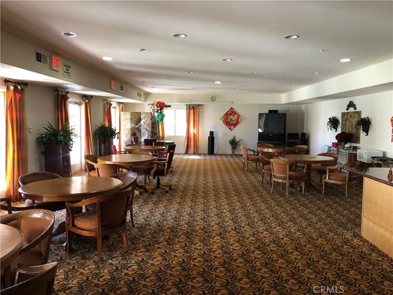 Room with tables and chairs arranged for recreational activities.