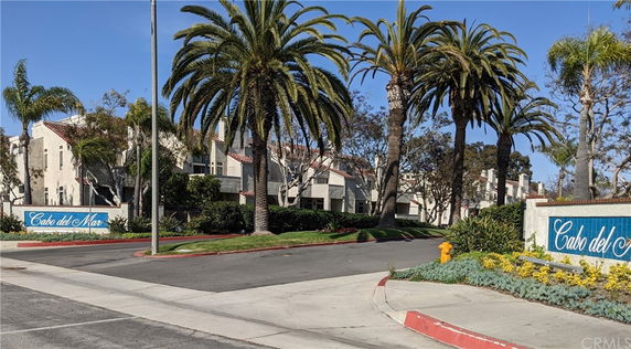 Front view of a residential complex with palm trees.