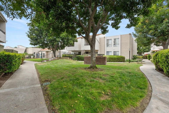 Exterior view of a residential building surrounded by trees and pathways.