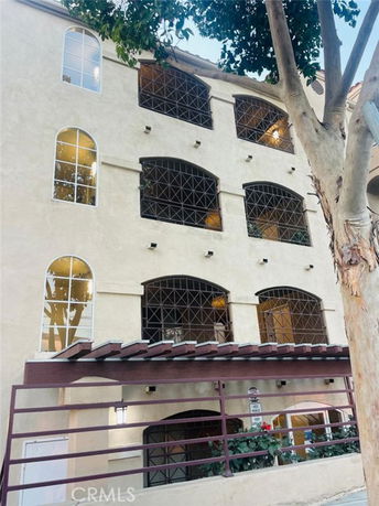 Front view of a building with multiple arched windows and metal railings.