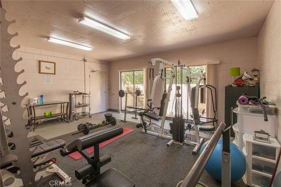 Indoor gym area with exercise equipment and weights.