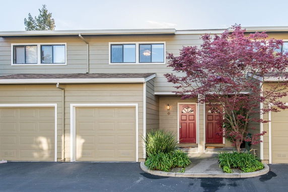 Front view of a two-story house with a double garage and red doors.