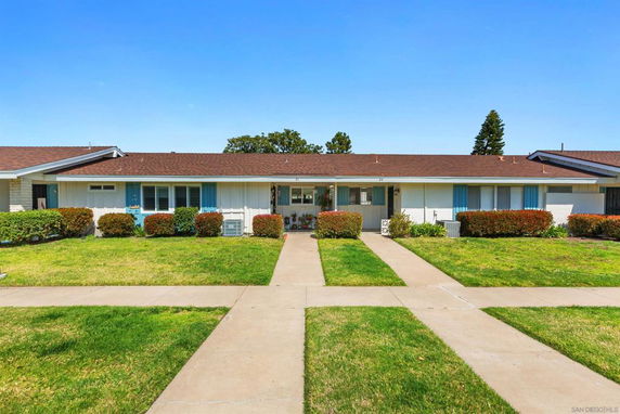 Front view of a single-story house with a brown roof and blue shutters.