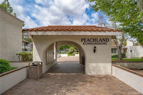 Front view of Peachland Condominiums entrance with archway and tiled roof.
