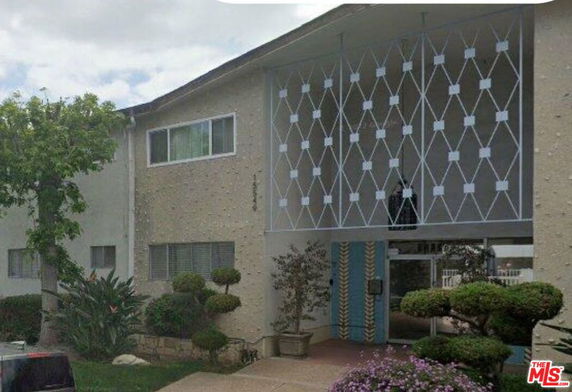 Front view of a two-story building with decorative facade and entrance area.