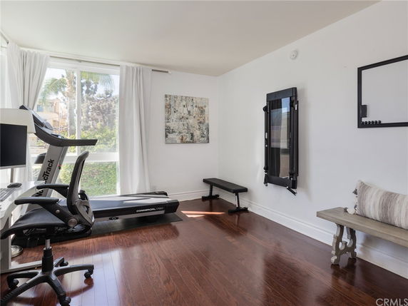 Interior room with exercise equipment including a treadmill and a bench.