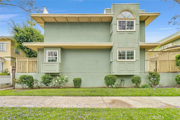 Side view of a two-story house with green exterior and multiple windows.