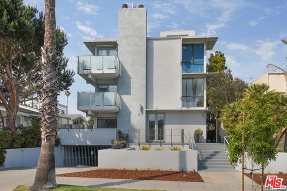 Front view of a modern multi-story building with balconies.