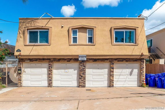 Front view of a two-story building with three garage doors.