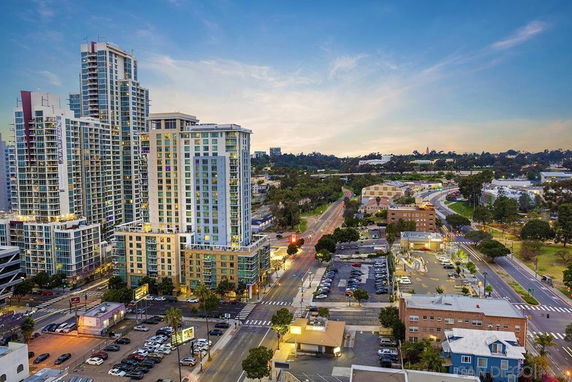 Aerial view of a cityscape with tall modern residential and commercial buildings.