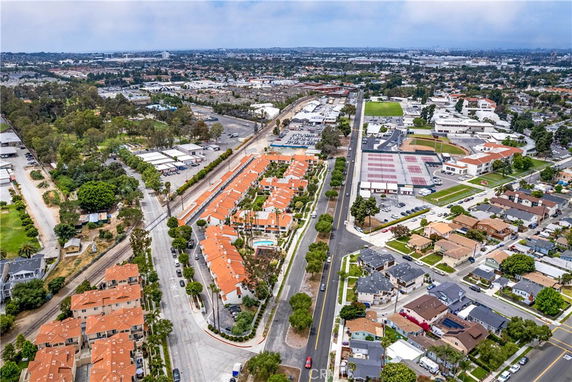 Aerial panoramic view of residential area with multiple houses and streets.