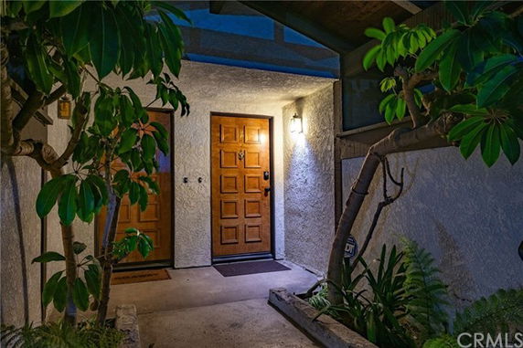 Front entrance of a house with wooden doors and outdoor lighting