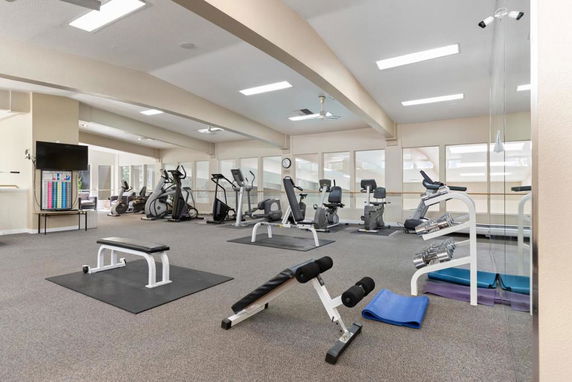 Indoor gym area with exercise equipment and mirrors.