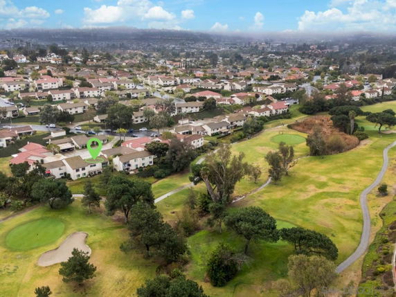 Aerial panoramic view of a residential area with houses and a nearby golf course.